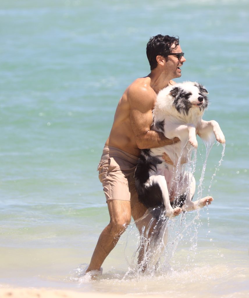 Marcos Pitombo com seu cachorro na praia da Barra da Tijuca