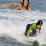 Dani Suzuki acompanha aula de surf do filho na Praia de Grumari