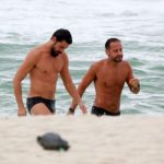 Cauã Reymond dá um mergulho na praia da Barra da Tijuca, com amigo