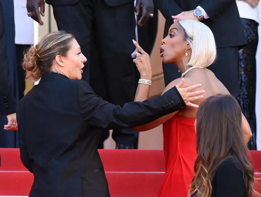 A cantora Kelly Rowland reage ao ser empurrada por uma francesa da segurança do Festival de Cannes para que saia logo do tapete vermelho
